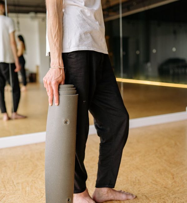 Man holding a difficult yoga balance pose, showing physical strength.